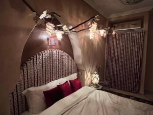 a bedroom with a bed with a wooden head board at Riad Al Ibtikar in Marrakesh
