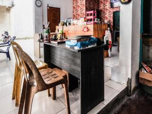 a wooden counter in a room with a chair at SPOT ON 91781 Solo Baru Homestay Syariah in Jodoh