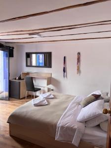a white bedroom with a large bed and a desk at Casona les Pleiades in Cusco
