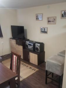 ein Wohnzimmer mit einem TV und einem Tisch in der Unterkunft Prenociste Lux in Kragujevac