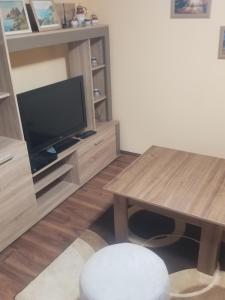 - un salon avec une télévision et une table en bois dans l'établissement Prenociste Lux, à Kragujevac