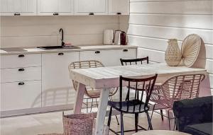 una cucina con tavolo, sedie e lavandino di Amazing Home In Mielno With Wifi a Mielno