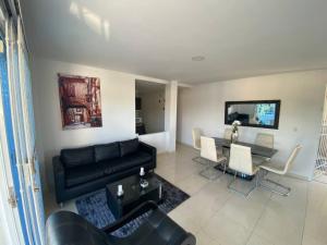 a living room with a black couch and a table at Lindo Apartamento vacacional in Cartagena de Indias