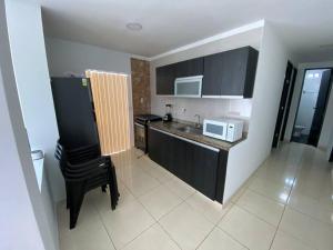 a small kitchen with a sink and a microwave at Lindo Apartamento vacacional in Cartagena de Indias