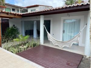 a porch with a hammock on the side of a house at Casa da Jana com piscina in Porto Seguro