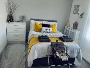 a bedroom with a bed with yellow and blue pillows at Centrally Located a Home from Home - Free Parking in Kent