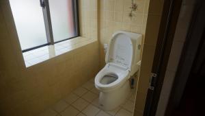 La salle de bains est pourvue de toilettes avec un couvercle. dans l'établissement Designer's Hotel Nakadoma Inn - Vacation STAY 32584v, à Maeganeku