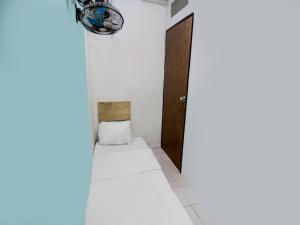 a hallway with a door and a white floor at SPOT ON 91781 Solo Baru Homestay Syariah in Jodoh