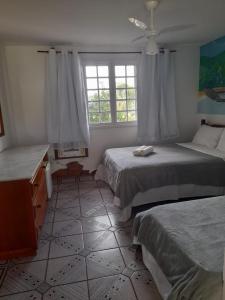 a bedroom with two beds and a window at pedra do porto II in Búzios