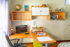 Una oficina con un escritorio con una computadora encima en Quarto junto ao mar, en Matosinhos 18 fotos más