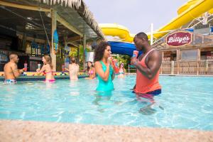 a man and woman standing in the water at a swimming pool at The Resort at Schlitterbahn in New Braunfels