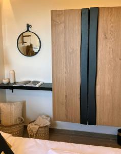 a bedroom with a bed and a mirror on the wall at Ski Suites - A Luxury Maisonette Kalavryta in Kalavrita
