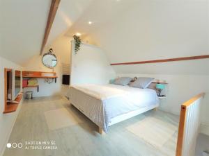 1 dormitorio con 1 cama en una habitación blanca en Gîte Les Hirondelles - Bord de mer et campagne, en Tracy-sur-Mer