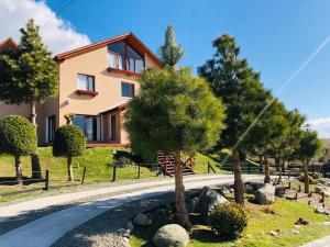 a house with trees in front of a road at Hotel Koi Mahik in El Calafate