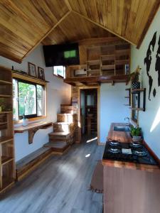 cocina con techos de madera y estufa en una habitación en Tiny House Nativa en Montecarlo