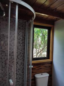 uma casa de banho com um WC e uma janela em Tiny House Nativa em Montecarlo