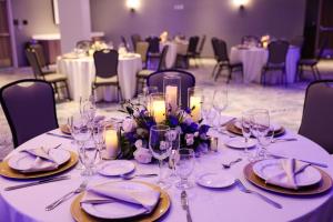 - une table avec des assiettes, des verres, des fleurs et des bougies dans l'établissement Cambria Hotel Fort Lauderdale Beach, à Fort Lauderdale
