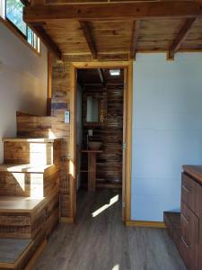 una puerta abierta en una habitación con paredes de madera en Tiny House Nativa en Montecarlo