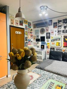 una habitación con un jarrón de flores sobre una mesa en Elly House en Casalecchio di Reno