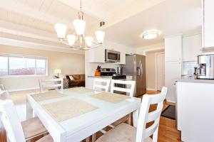 a kitchen and dining room with a white table and chairs at Beautiful Views - Sand Section of Manhattan Beach 2 Bed/2 Bath in Manhattan Beach