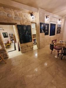 une grande chambre avec des peintures sur les murs et une table dans l'établissement Reeja art gallery, à Nazareth