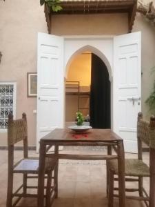 una sala da pranzo con tavolo e 2 sedie di Hostel Laksour a Marrakech