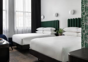 Habitación de hotel con 2 camas y almohadas blancas en Woodlark en Portland