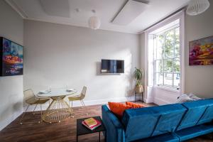 ein Wohnzimmer mit einem blauen Sofa und einem Tisch in der Unterkunft Dalton Sq Apartment 1 in Lancaster