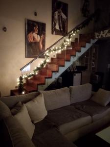 a living room with a couch and a staircase with lights at Lia Luxury home 2ΥΔ 110 τ μ in Chrysoupolis