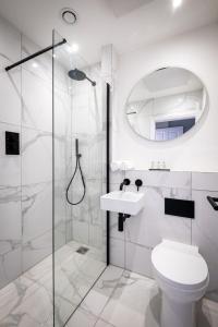 La salle de bains blanche est pourvue d'une douche et de toilettes. dans l'établissement Dalton Sq Apartment 1, à Lancaster