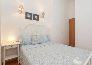 a bedroom with a bed and a nightstand with a white bedspread at Downtown Lisbon in Lisbon