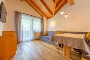 ein Wohnzimmer mit einem Tisch und einem Sofa in der Unterkunft Alpengruss in Innichen