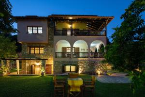 a house with a table and chairs in the yard at Vetrinos Apartments in Ayios Nikolaos Sithonia