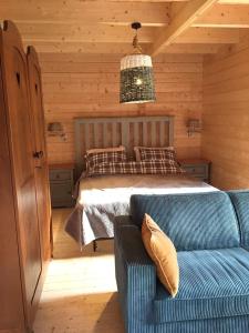a bedroom with a bed and a couch in a room at Chalet Ons Oekje in Vrouwenpolder