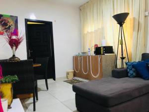 ein Wohnzimmer mit einem Sofa und einem Tisch in der Unterkunft Serenity in Accra
