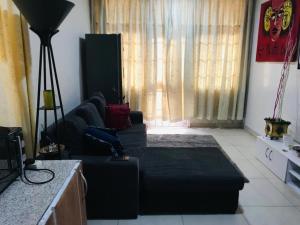 a living room with a black couch and a window at Serenity in Accra