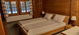 a bedroom with a bed in a room with a window at Emme Lodge in Langnau