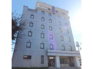 un edificio blanco alto con luces moradas. en Suzuka Royal Hotel - Vacation STAY 38899v, en Suzuka