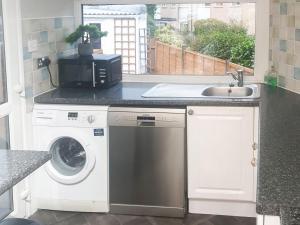 a kitchen with a washing machine and a sink at Moor View in Newton Abbot
