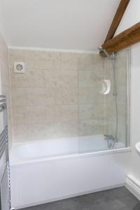 a shower with a glass door in a bathroom at Beautiful barn conversion surrounded by woodland near Newark Show-ground 
