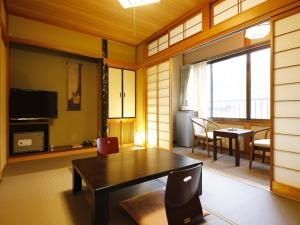a living room with a table and a dining room at Ryokan Kutsuroginoya Yuu in Takayama +27 photos