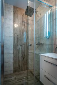 a bathroom with a glass shower and a sink at Villa Balos in Gronków