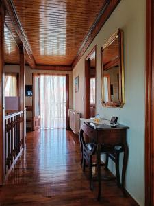 a dining room with a table and a mirror at Wooden Sofita House with Unlimited View in Grevena