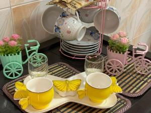a table with two cups and a plate with butterflies on it at بيت الطبيعة nature house in Jerash