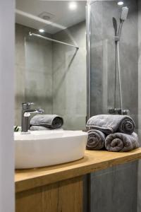 La salle de bains est pourvue d'un lavabo, d'une douche et de serviettes. dans l'établissement Nowotarżanka, à Nowy Targ