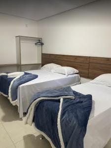 2 camas en una habitación con baño de vapor en Hotel Vitória, en Vitória da Conquista