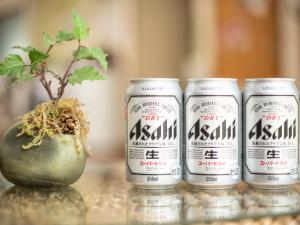 quatre canettes de bière asahi assises à côté d'une plante dans l'établissement Yamanaka Lake ＲＹＯＺＡＮ - Vacation STAY 32161v, à Yamanakako