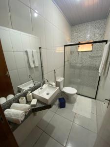 Baño blanco con lavabo y aseo en Canto das Águas, en Alagoa