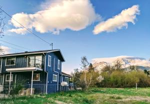 a blue house with mountains in the background at 4 Elements House:Central, Views-Every Rm, AC, Pets in Mount Shasta