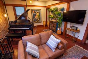 a living room with a couch and a piano at Perfect Urban Sanctuary for 8 w Hot Tub near City Park in Denver